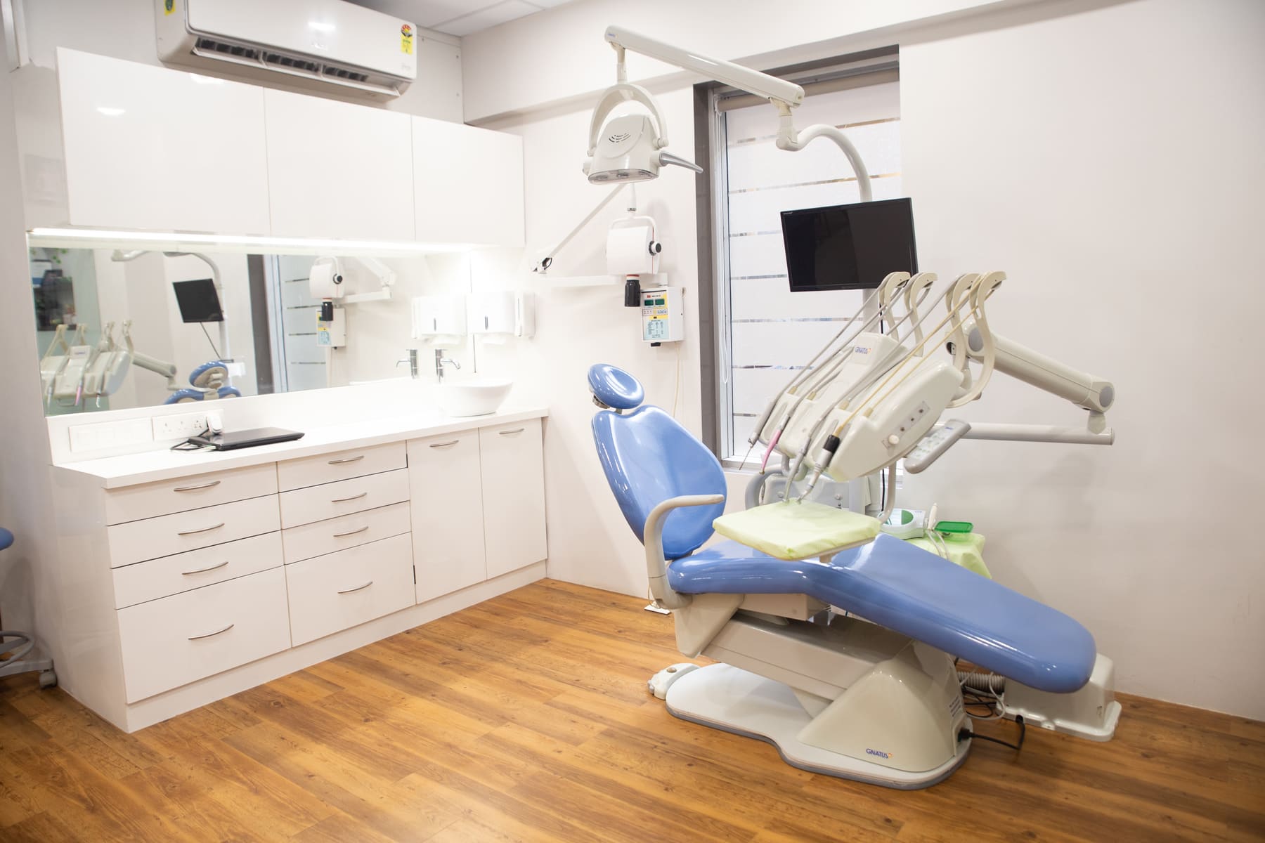 Treatment room at i-Smile Dental Clinic with dental chair and screen